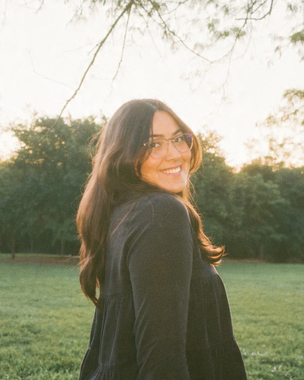 Dannyela Louize sonriendo en un parque al atardecer